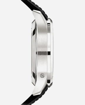 Side view of the silver Relógio Patek Aquanaut with a black strap, showcasing its polished and brushed metal case and thickness against a light background—a modern nod to refined style.