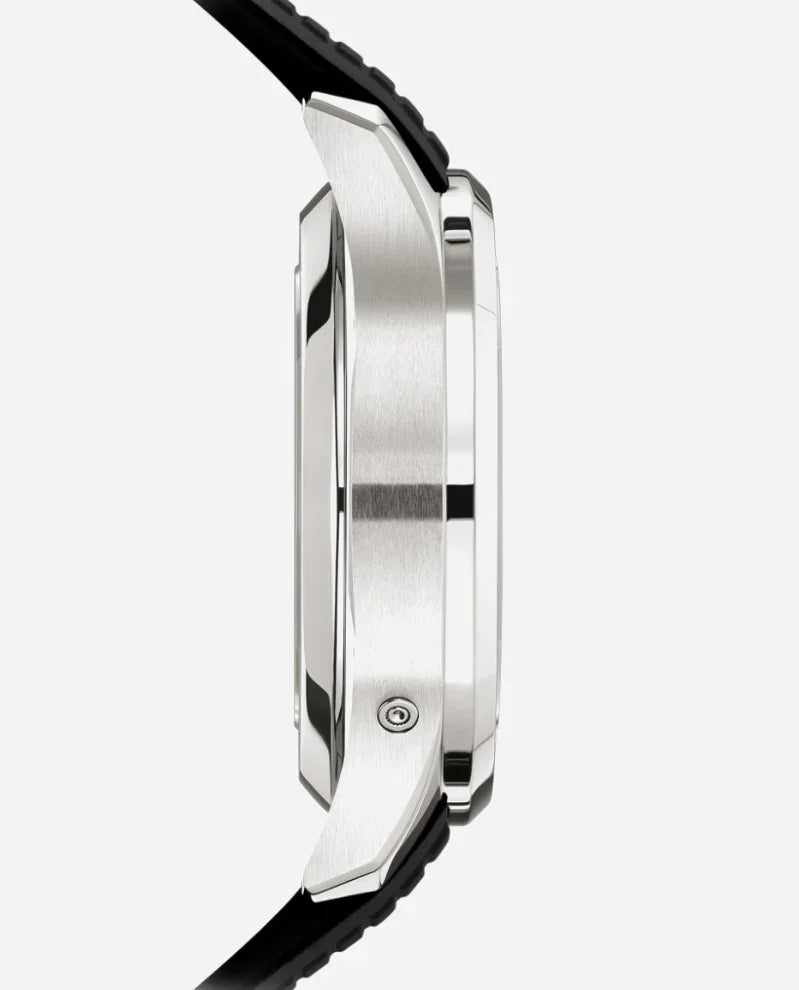 Side view of the silver Relógio Patek Aquanaut with a black strap, showcasing its polished and brushed metal case and thickness against a light background—a modern nod to refined style.